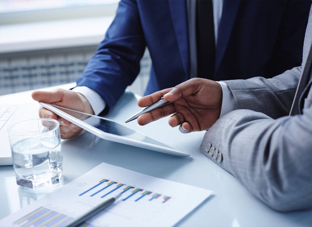 Service Center - Two Business Men Looking at a Tablet With Graph Papers